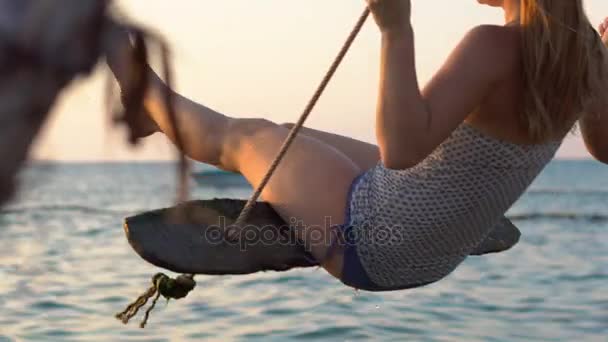 Lycklig kvinna svängande på en rep sving med en paradise tropiska havet i bakgrunden — Stockvideo