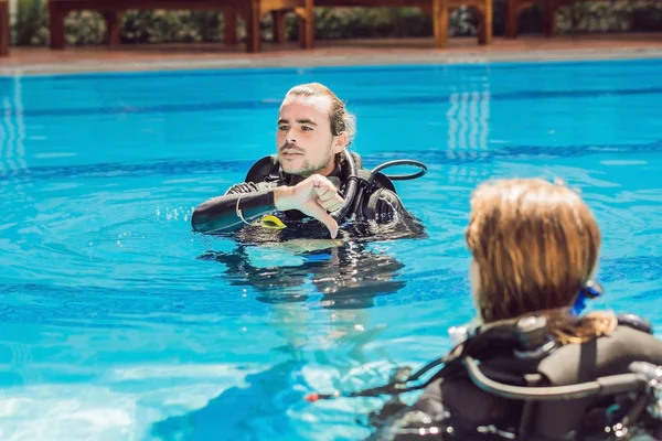 Diving instructor and students. Instructor teaches students to dive.