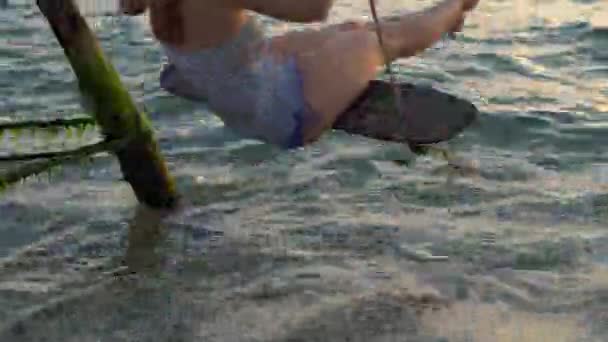 Mutlu kadın bir ip salıncak arka planda bir cennet tropikal deniz üzerinde sallanan — Stok video
