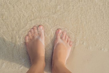 Kadın gündüz, beyaz kumlu plaj bacaklarına closeup