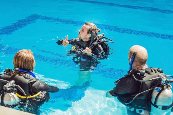 Diving instructor and students. Instructor teaches students to dive — Stock Photo, Image