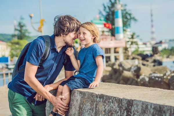 Padre e figlio viaggiatori sullo sfondo Dinh Cau faro simbolo dell'isola di Phu Quoc, Vietnam. Phu Quoc è un'isola vietnamita al largo della costa cambogiana nel Golfo di Thailandia — Foto Stock