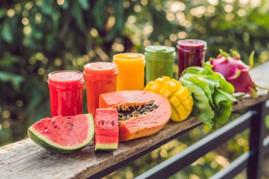 Smoothies gökkuşağı. Karpuz, papaya, mango, ıspanak ve dragon meyve. Smoothies, meyve suları, meyve suyu, içecekler, içecekler çeşitli taze meyve ile ahşap bir masaya.