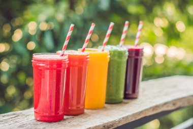 Smoothies gökkuşağı. Karpuz, papaya, mango, ıspanak ve dragon meyve. Smoothies, meyve suları, meyve suyu, içecekler, içecekler çeşitli taze meyve ile ahşap bir masaya.