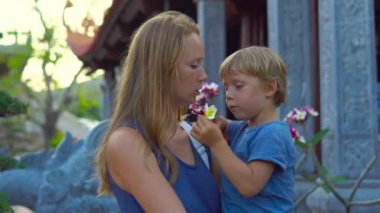 Kadın ve oğlu kokla frangipani içinde çiçek bir budhist temple Ho Quoc Pagoda Phu Quoc Adası, Vietnam