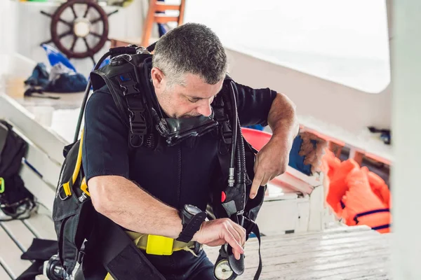 Duiker bereidt zijn apparatuur voor duiken in de zee — Stockfoto