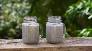 Chia tohum pudingle badem sütü ve ahşap bir masa üzerinde taze mango tepesi