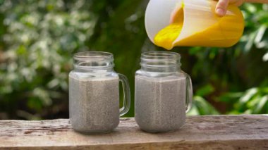Chia tohum pudingle badem sütü ve ahşap bir masa üzerinde taze mango tepesi