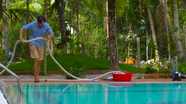 スイミング プールの洗浄剤です スイミング プール 日当たりの良い洗浄と青シャツの男 — ストック動画