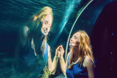 Genç kadın bir tünel akvaryum balık bakarak