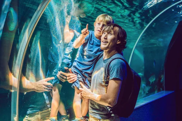 Padre e figlio che guardano i pesci in un acquario a tunnel — Foto Stock