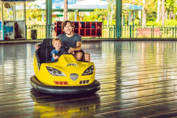 Father and son having a ride in the bumper car at the amusement park — Stock Photo, Image