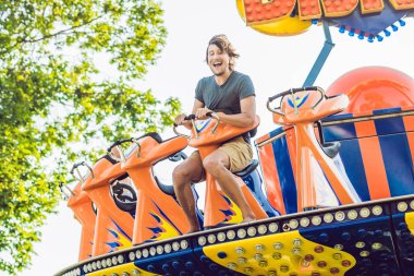 Güzel, genç adam bir eğlence parkında eğleniyor