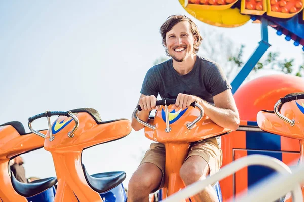 Hermoso, joven hombre divirtiéndose en un parque de atracciones — Foto de Stock