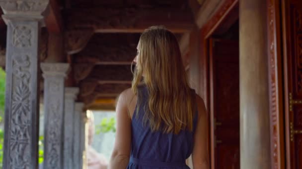 Steadycam fotografió a una joven mujer caminando dentro de un templo budista. Pagoda Ho Quoc en la isla Phu Quoc, Vietnam — Vídeo de stock