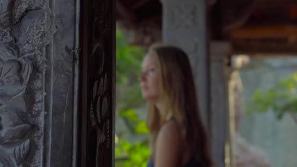 Schwebestativ-Aufnahme einer jungen Frau, die innerhalb eines buddhistischen Tempels geht. ho quoc pagode auf phu quoc insel, vietnam — Stockvideo
