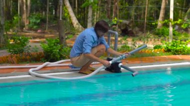 Yüzme Havuzu temiz. Yüzme havuzları, güneşli için ekipman temizleme ile mavi gömlekli adam.