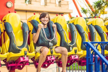 Güzel, genç adam bir eğlence parkında eğleniyor
