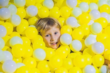 Renkli plastik oynarken mutlu küçük çocuk Çocuk Bahçesi yüksek görünüm topları. Çok güzel çocuk içeride eğleniyor.