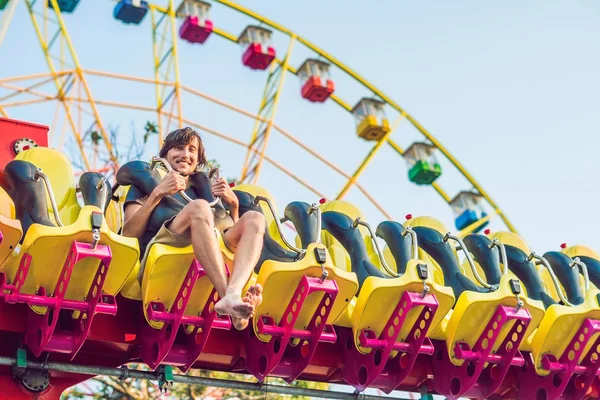 Hermoso, joven hombre divirtiéndose en un parque de atracciones — Foto de Stock