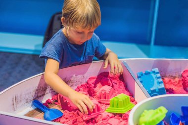 Okul öncesi Kinetik kumla oynayan çocuk. İnce motor kavramı geliştirilmesi. Yaratıcılık oyun kavramını.