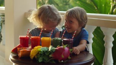 Çocuk renkli sağlıklı smoothies iç. Karpuz, papaya, mango, ıspanak ve dragon meyve. Smoothies, meyve suları, meyve suyu, içecekler, içecekler çeşitli taze meyve ile ahşap bir masaya.