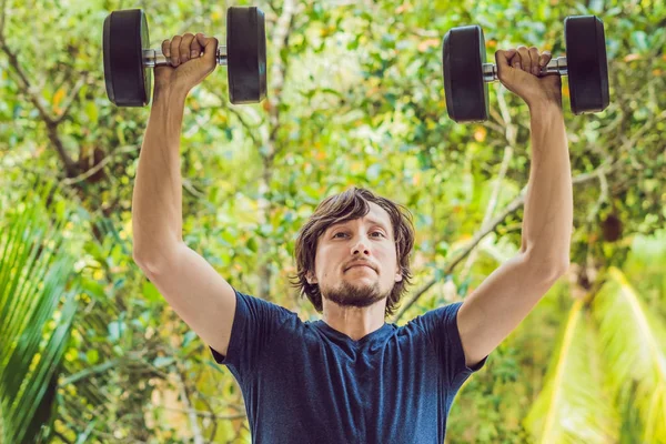 Bicep curl - weight training fitness man outside working out arms lifting dumbbells doing biceps curls. Male sports model exercising outdoors as part of healthy lifestyle — Stock Photo, Image