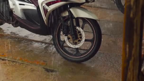 Tiro de câmera lenta de uma chuva pesada e água falhando de um telhado em uma motocicleta — Vídeo de Stock