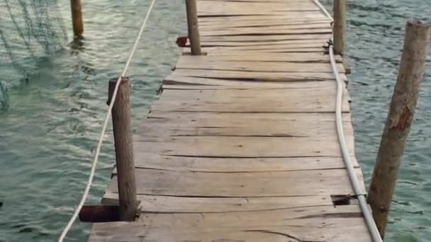 Slowmotion steadycam toma de una pasarela de madera sobre un mar a un restaurante — Vídeos de Stock
