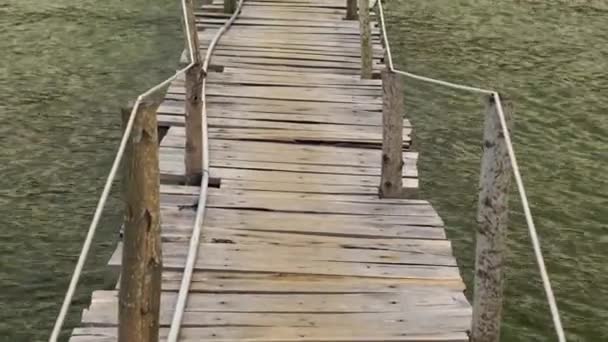 Slowmotion steadycam toma de una pasarela de madera sobre un mar a un restaurante — Vídeos de Stock