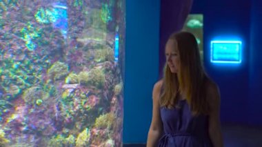 Aile bir oceanarium ziyaret etti. Steadycam çekim tarafından büyük bir akvaryum tropikal balıklar ile yürüyen bir kadın
