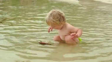 Bir bebek ile kırmızı deniz yıldızı bir kumsalda oynarken fotoğrafını Slowmotion