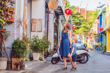 Anne ve oğlu Portekizce sokakta yürürken Romani Phuket Town oteli tarzı. Chinatown veya eski şehir olarak da bilinir. Çocuk kavramı ile seyahat