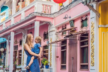 Anne ve oğlu Portekizce sokakta yürürken Romani Phuket Town oteli tarzı. Chinatown veya eski şehir olarak da bilinir. Çocuk kavramı ile seyahat