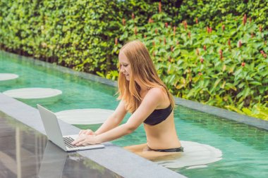 Onun smartphone içinde tarama otelde onu laptop ile havuzun oturan genç kadın serbest meslek sahibi. Bayramlarda meşgul. Uzak iş kavramı. Metniniz için kopya alanı.