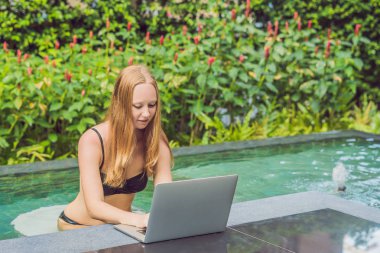 Onun smartphone içinde tarama otelde onu laptop ile havuzun oturan genç kadın serbest meslek sahibi. Bayramlarda meşgul. Uzak iş kavramı. Metniniz için kopya alanı.