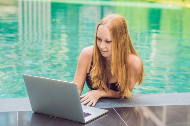 Onun smartphone içinde tarama otelde onu laptop ile havuzun oturan genç kadın serbest meslek sahibi. Bayramlarda meşgul. Uzak iş kavramı. Metniniz için kopya alanı.