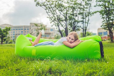 Parkta bir hava kanepede oturan genç kadın. lamzac