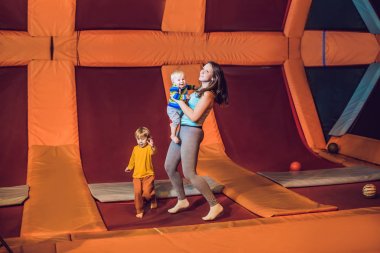 Anne ve oğlu fitness Park'ta bir trambolin üzerinde atlama ve kapalı exersice yapıyor.