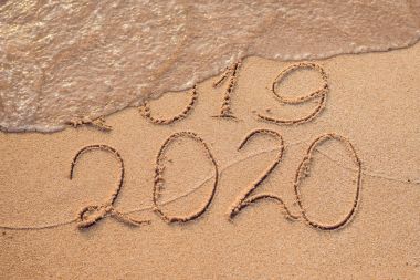 Yeni yıl 2020 önümüzdeki kavram - yazıt 2019 ve 2020 bir plaj kum, dalga neredeyse basamak 2019 koruyor.