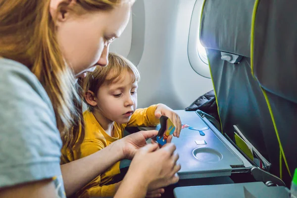Family playing with a board game on a flight.