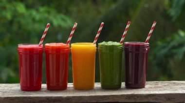 Smoothies gökkuşağı. Karpuz, papaya, mango, ıspanak ve dragon meyve. Smoothies, meyve suları, meyve suyu, içecekler, içecekler çeşitli taze meyve ile ahşap bir masaya
