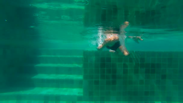 Ultrahd slow motion submarino disparo de un niño buceando en la piscina . — Vídeo de stock