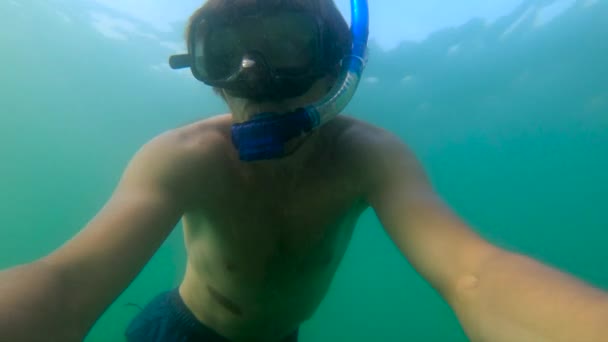 Lentidão ultrahd tiro subaquático de um homem snorkeling no mar em uma ilha tropical — Vídeo de Stock