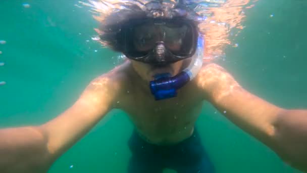 Lentidão ultrahd tiro subaquático de um homem snorkeling no mar em uma ilha tropical — Vídeo de Stock