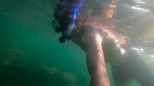 Сверхмедленное движение под водой снимок человека, ныряющего с маской в море на троичном острове — стоковое видео