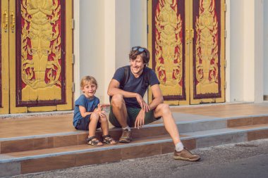 Baba ve oğul turist Tayland Phuket Town Wat Mongkolnimit tapınakta. Çocuk kavramı ile seyahat.