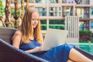 Onu laptop ile havuz oturan genç kadın serbest meslek sahibi. Bayramlarda meşgul. Uzak iş kavramı 