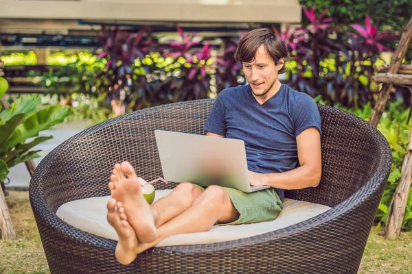 Young freelancer working on vacation next to swimming pool