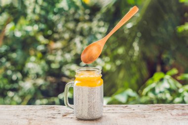 Chia tohum puding badem süt ve taze mango kaşık levitating ile tepesi.